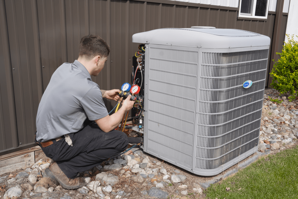 Tyler Heating & Cooling employee inspecting and servicing a commercial heat pump
